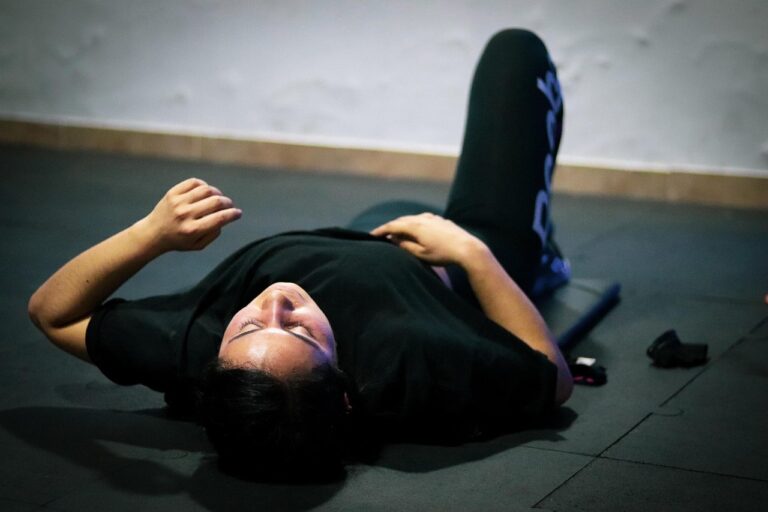 Atleta recuperándose en el suelo del gimnasio