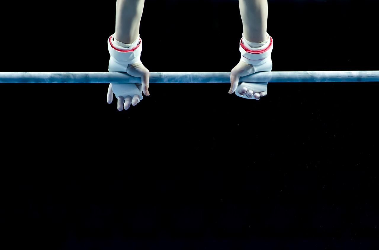 Manos de un atleta agarrando una barra de dominadas