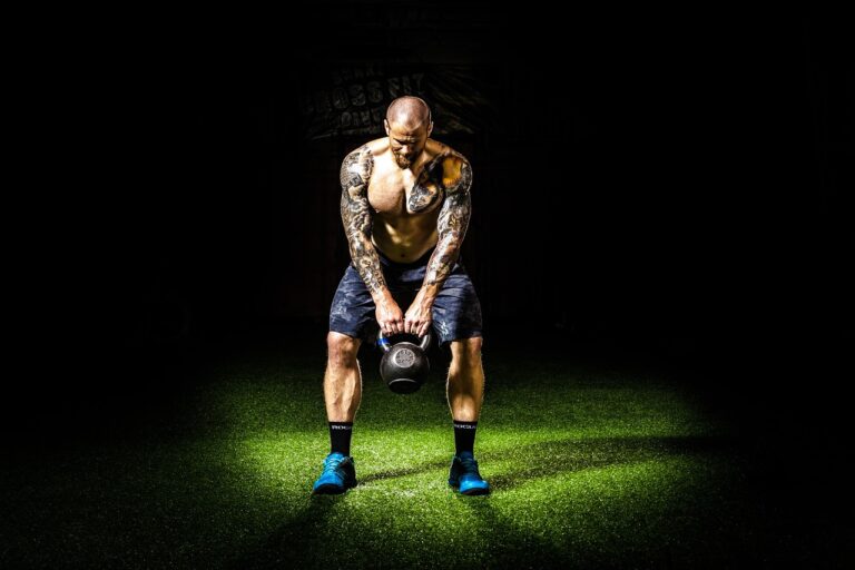 Atleta entrenando con esfuerzo en un gimnasio oscuro
