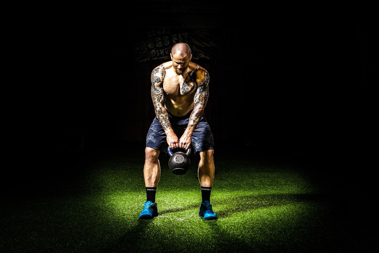 Atleta entrenando con esfuerzo en un gimnasio oscuro